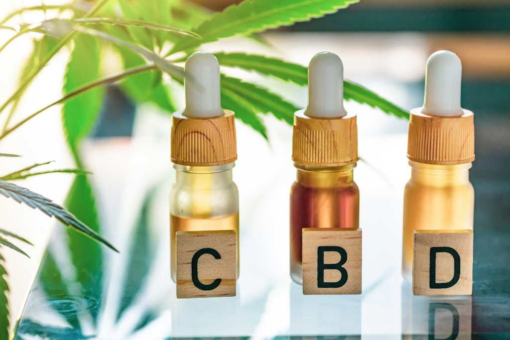 Three tincture bottles beside wooden blocks labeled C, B, and D