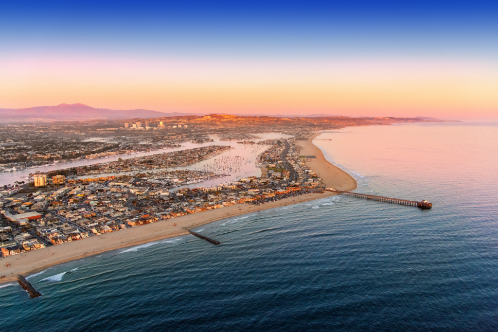 Aerial view of Newport Beach coastline and pier at sunset